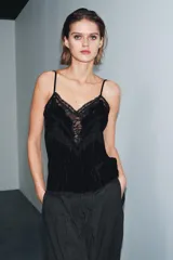 Top de terciopelo negro con escote en pico, tirantes finos ajustables y detalles de encaje a tono en el escote y el bajo.