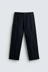 Pantalón de corte recto, color azul marino, confeccionado en tejido jacquard con textura de rayas verticales en relieve. Presenta cierre frontal con botón y bolsillos laterales y traseros de vivo.