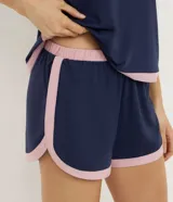 Conjunto de pijama corto compuesto por una musculosa de breteles finos y un short con cintura elástica. Ambas piezas son de color azul marino con detalles de bies en color rosado en los bordes.