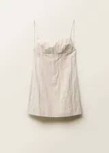 Vestido corto color crema, de breteles finos, escote recto con detalle de flecos y espalda descubierta.