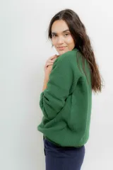 Sweater de punto en color crema con rayas horizontales en tono dorado. Presenta un diseño de cuello redondo con una solapa lateral decorada con botones metálicos dorados y corte holgado.