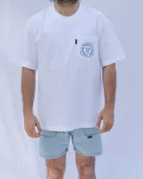 Remera blanca de algodón con cuello redondo y bolsillo en el pecho con logo estampado en azul.