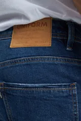 Pantalón de jean azul oscuro, corte slim, con bolsillos delanteros y traseros.