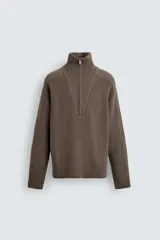 Jersey de punto de corte relajado, color marrón, con cuello perkins y cierre frontal de cremallera. Presenta manga larga y acabados en rib en puños y bajo.