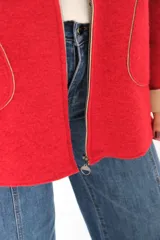 Tapado de paño rojo con capucha, cierre frontal y detalles en color beige en el interior, puños y bordes de los bolsillos. Presenta un corte recto y holgado.
