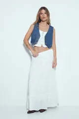 Top corto color marrón, con escote cuadrado y breteles anchos con volados. Presenta frunces horizontales en el torso y una hilera de botones nacarados en el centro frontal.