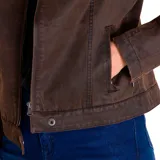 Chaqueta estilo moto de tela encerada color marrón, con cierre frontal metálico, cuello tipo mao con broche a presión y bolsillos con cierre en los laterales.