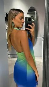 Vestido corto con diseño degradado en tonos azul y verde, de cuello halter con abertura frontal y detalle de nudo lateral con lazo.