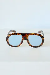 Lentes de sol con armazón de acetato en estampado carey y cristales celestes con protección UV400.