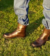 Botas de cuero color marrón chocolate con suela de goma tipo track en color negro. Presentan un diseño de caña media con cierre frontal metálico y costuras reforzadas.