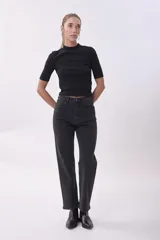 Pantalón de jean negro de corte recto con sutiles detalles de brillo en toda la prenda. Presenta tiro alto, cierre frontal con botón y bolsillos laterales y traseros.