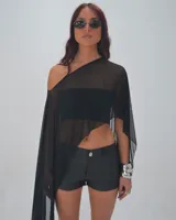 Capa asimétrica de tul negro con diseño de un solo hombro y caída fluida.