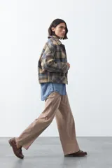 Pantalón de pana color marrón chocolate, de corte recto con bolsillos laterales y cierre frontal.