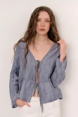 Chaqueta ligera de manga larga en color azul, con escote en V y cierre frontal con dos lazos para atar.