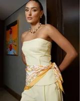 Top strapless color amarillo con detalle de costuras verticales en el frente.
