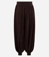 Pantalón de punto estilo aladino, color marrón oscuro, con diseño de tejido calado, cintura elástica y puños ajustados en los tobillos.