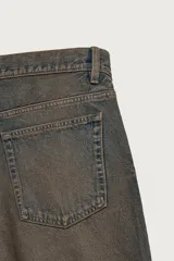 Bermuda de denim de algodón con efecto lavado desgastado en tonos marrones y azules. Tiene tiro medio, diseño de cinco bolsillos, pierna recta de corte holgado y bajo con acabado irregular. Cuenta con cierre frontal de cremallera y botón metálico.
