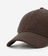 Gorra de feltro con ala curva y ajuste trasero mediante velcro. Diseño liso y minimalista.