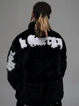 Campera de piel sintética negra con cuello alto y cierre frontal. Presenta letras bordadas en color blanco en la espalda y en las mangas.