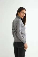 Polera de cuello alto y manga larga, confeccionada en tejido de punto fino con un diseño ajustado al cuerpo.