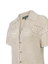 Cardigan de punto calado color beige, con cuello camisero, manga corta y cierre frontal con botones.