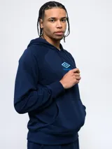 Canguro Umbro de felpa con capucha y cordones ajustables. Presenta el logo de la marca bordado en el pecho en color celeste y bolsillo frontal tipo canguro.