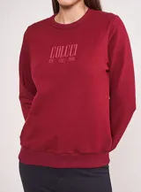 Buzo de algodón color bordó, con cuello redondo acanalado y estampa frontal con el logo de la marca Colcci.
