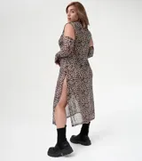 Vestido tipo túnica de microtul con estampado animal print, corte holgado, cuello alto y mangas largas con aberturas en los hombros.