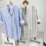 Camisa de hombre de algodón a rayas verticales celestes y blancas, con cuello mao y mangas 3/4 con puños arremangados.