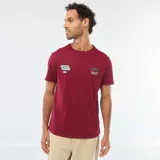 Remera de cuello redondo y manga corta color bordó, con estampado gráfico pequeño en el pecho que incluye logotipos de estilo automotriz.