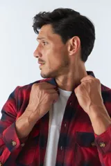 Sobrecamisa de algodón a cuadros color ladrillo, con interior de corderito, cierre con botones, bolsillos tipo cartera y logo en goma. El modelo usa talle M.