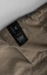Bermuda tipo cargo color beige, con bolsillos laterales con solapa, trabillas para cinto y cierre frontal con botón y cremallera.