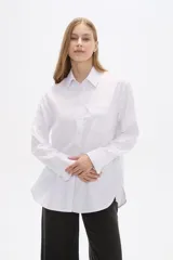 Camisa blanca de poliéster, corte holgado, con cuello camisero y cierre frontal con botones.