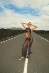 Vestido largo de tul negro con diseño de corte asimétrico en la cintura y cuello redondo. Confeccionado en tejido semitransparente.