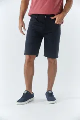 Bermuda clásica de jean color beige, con cinco bolsillos, cierre con cremallera y botón.