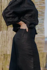 Pantalón palazzo color crudo con detalle de cinta bordada en los laterales y lazo en la cintura.