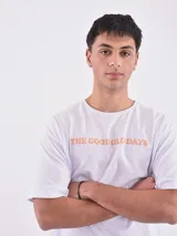 Remera blanca de corte holgado con la frase "The Good Old Days" estampada en color naranja.