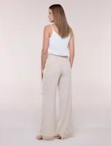 Pantalón de vestir de tiro alto, color beige, con corte wide leg y pinzas frontales.