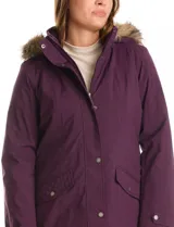 Gabardina impermeable color violeta con capucha desmontable con borde de piel sintética. Presenta cierre frontal oculto con botones a presión, bolsillos laterales con solapa y costuras matelassé, y ajuste interno en la cintura. El diseño incluye detalles capitoneados en hombros y espalda, y trabas en los puños.