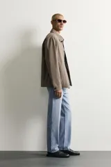 Pantalón de jean corte slim fit con efecto lavado, tiro medio, cinco bolsillos y cierre frontal con cremallera y botón.