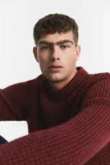 Sweater de punto con textura en relieve, cuello redondo y mangas largas. Presenta puños y ruedo acanalados.