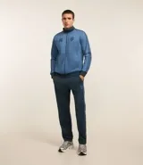Pantalón deportivo azul con cintura elástica, frisos y rayas en los laterales, estampa localizada y bolsillos.