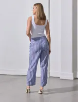 Pantalón de lino estampado a rayas verticales azules y blancas, marca DASH. Tiene pretina ancha elastizada con lazo ajustable.