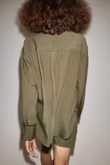 Camisa fluida de mujer de la ZW Collection de Zara, confeccionada en mezcla de viscosa, con diseño a rayas en tonos verde militar y marrón oscuro. Presenta cuello solapa, manga larga con puños anchos terminados en ribete negro a contraste, bolsillo de parche en el pecho con ribete a juego, bajo redondeado y cierre frontal con botones oscuros.