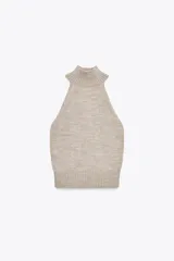 Top de punto sin mangas con cuello halter y hombros descubiertos, con terminaciones en tejido rib en cuello y ruedo.