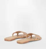 Sandalias planas color beige con detalle de logo de ojo en la tira superior.