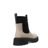 Botas Chelsea de mujer color nude (beige claro) con caña de tejido elástico negro acanalado. Posee suela track gruesa y dentada de goma negra y tirador trasero de tela negra.