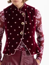 Chaleco de velvet color bordó con estampado floral, cuello mao y terminaciones con vivo en contratono. El acceso es mediante cruce diagonal con broches dorados. Tiene pinzas delanteras y traseras que le dan un fit al cuerpo y un sutil efecto evasé en la parte inferior.