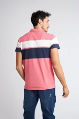 Remera polo de manga corta con diseño de franjas horizontales en colores rosado, blanco y azul marino. Cuenta con cuello clásico, cierre frontal de dos botones y logo pequeño estampado en el pecho.