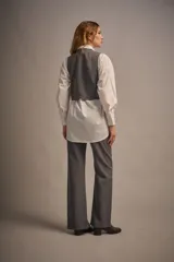 Pantalón gris de vestir con corte flare y abertura lateral en el ruedo.